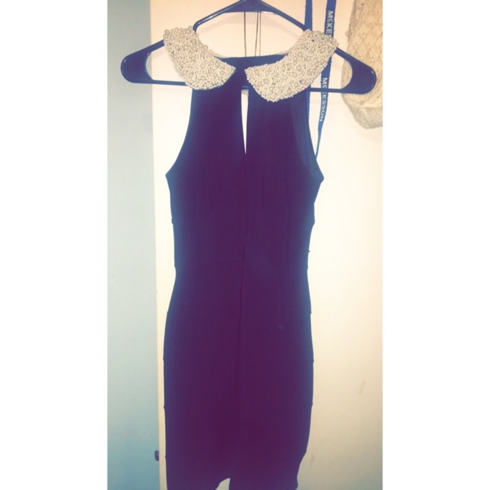 Black dress with pearl collar.